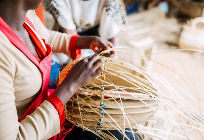 Woman weaving a basket in Rwanda, Africa